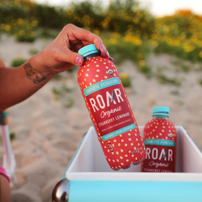 Khris holding bottle of ROAR Organic